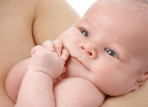 Cute newborn in mother's hands, looking at mother